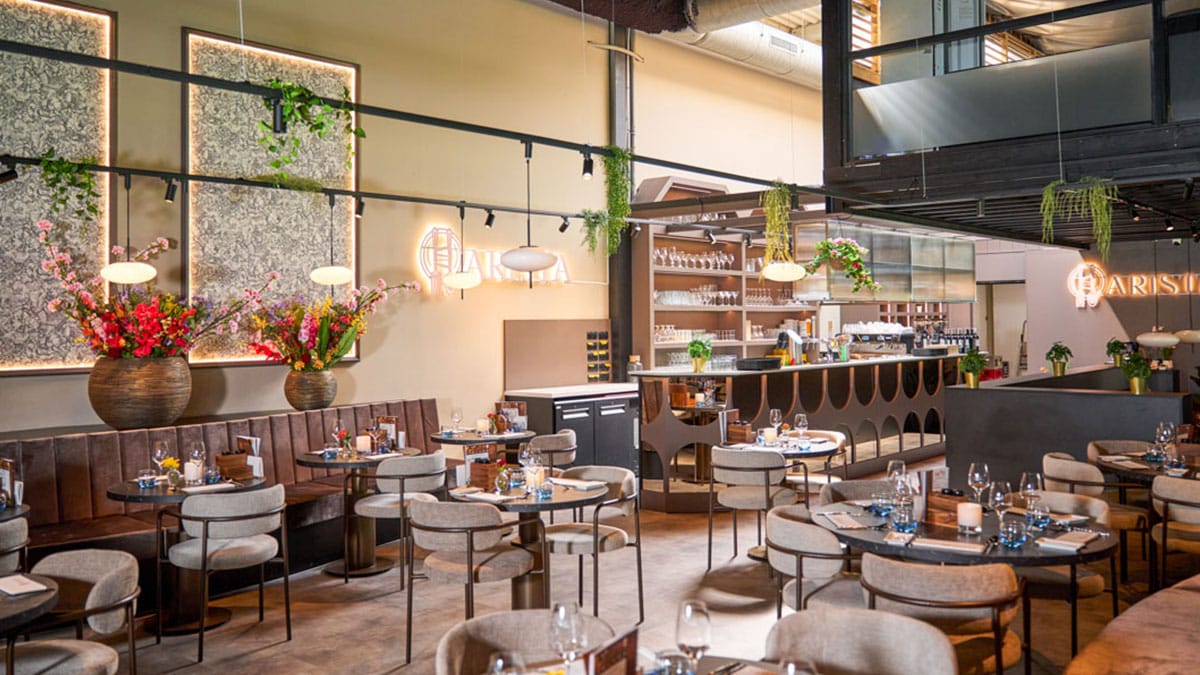 Licht restaurant met tafels, stoelen en een open bar