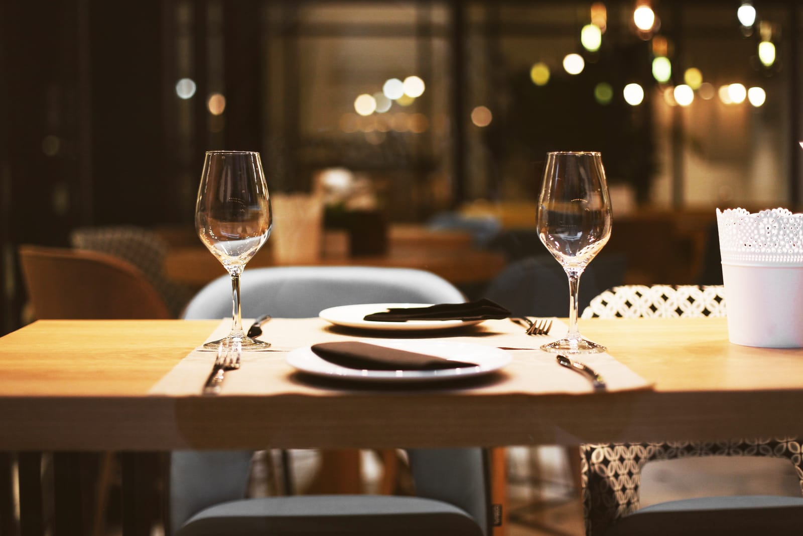 Gedekte restauranttafel met wijnglazen in warm licht