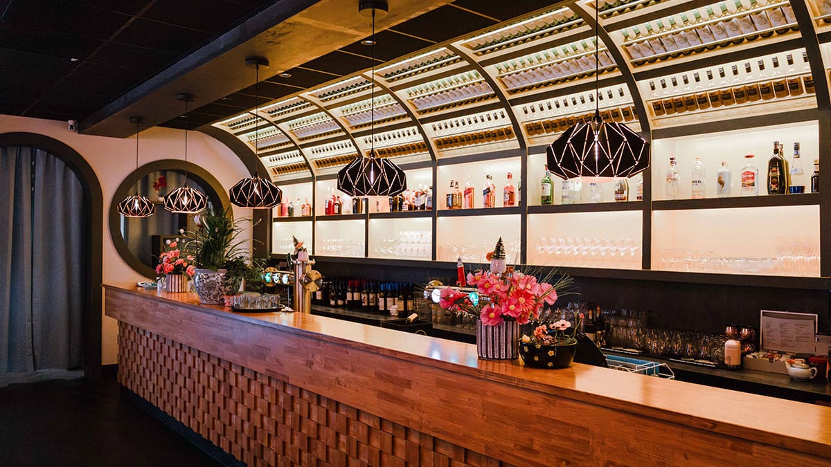 Bar met flessen en hanglampen in een restaurant