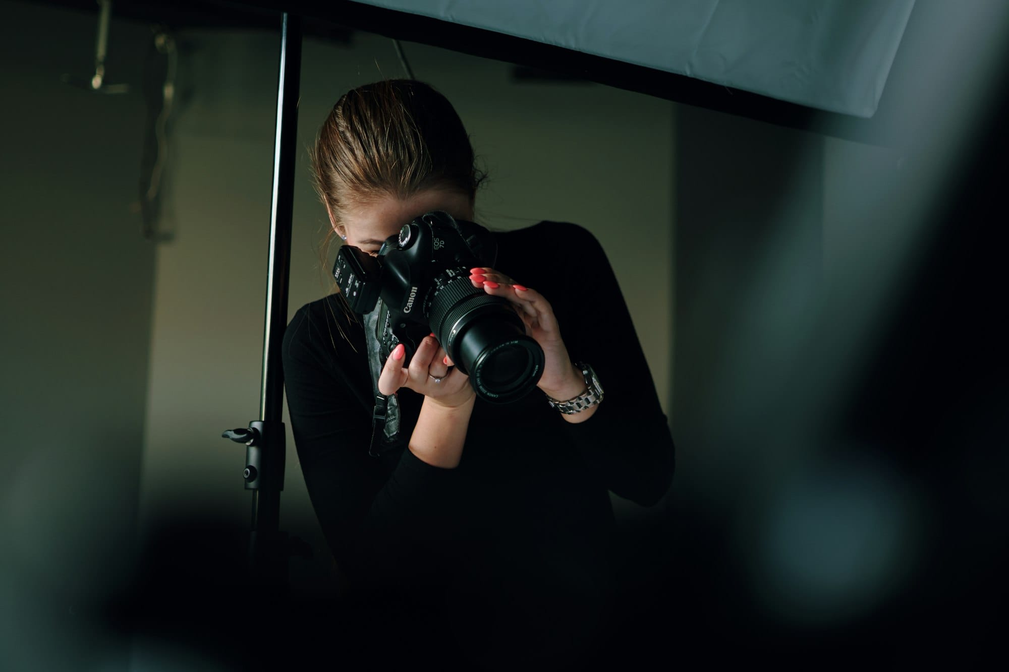 Fotografe met camera aan het werk in een donkere studio