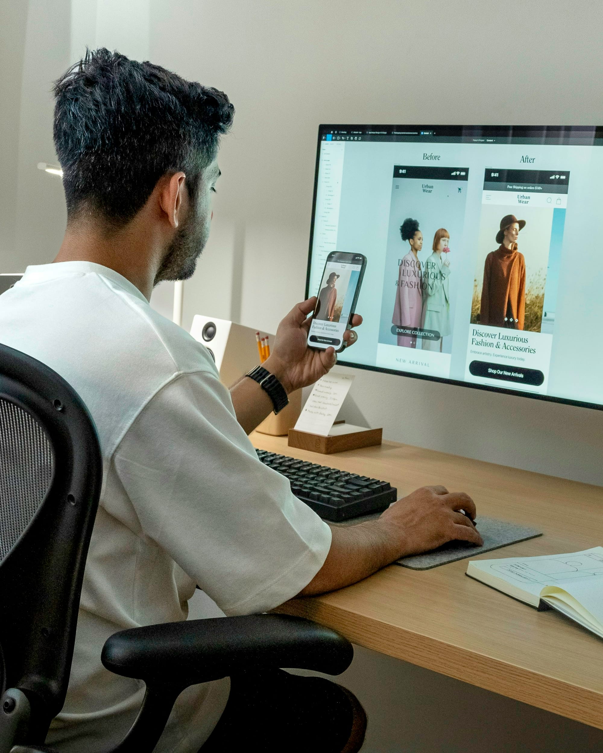 Ontwerper vergelijkt een websiteontwerp op zijn telefoon en een groot scherm