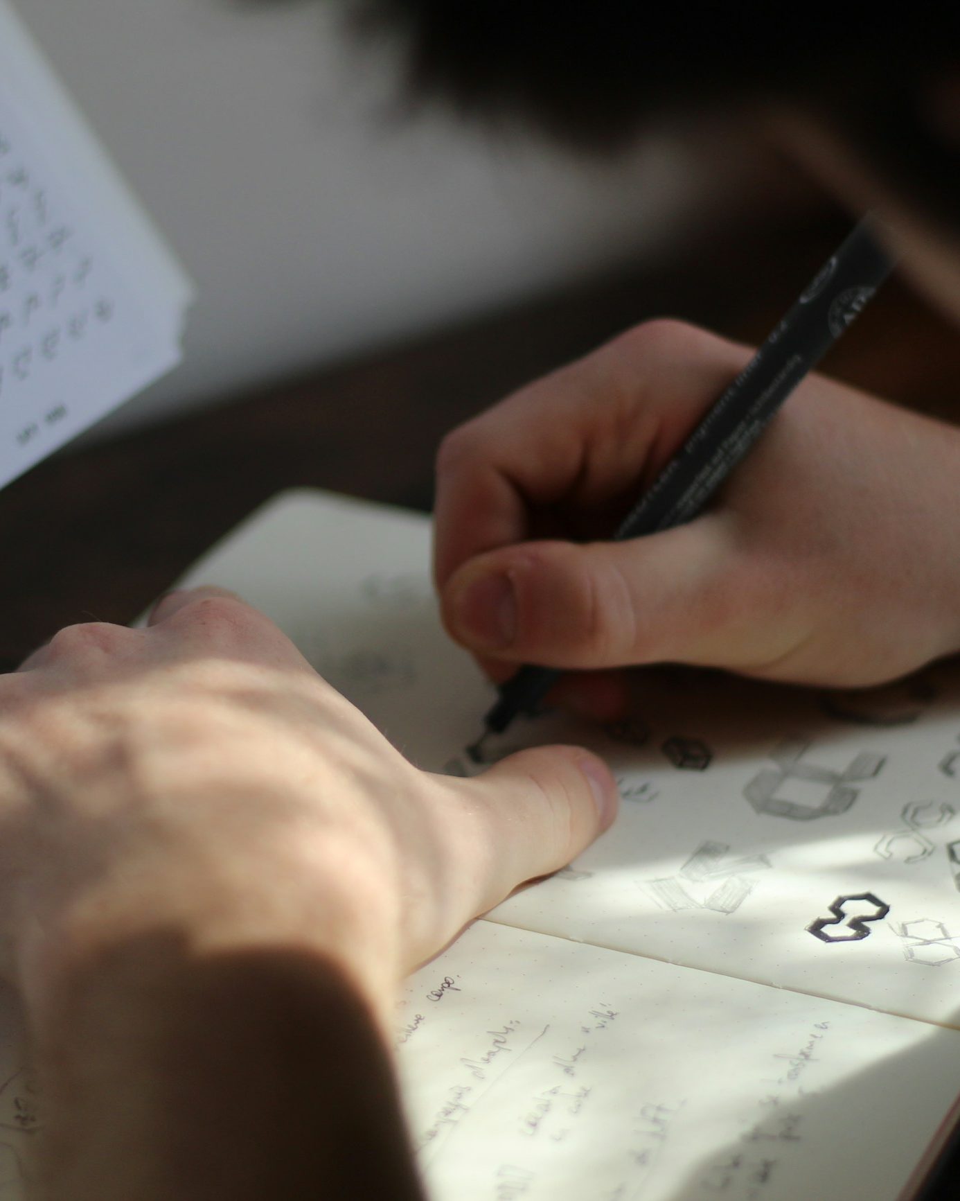 Ontwerper schetst logo's in een notitieboek