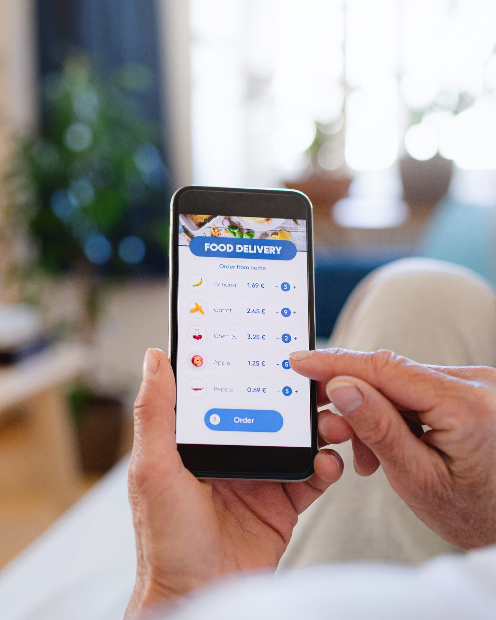 Hand houdt in een café een telefoon vast met een app om eten te bestellen